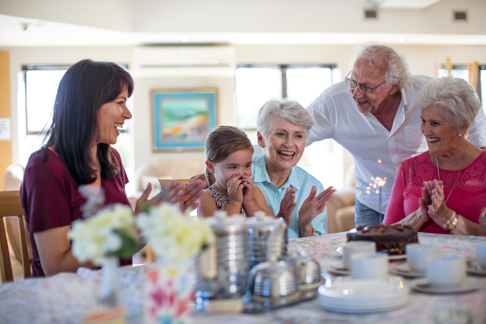 Grandparents celebrating a birthday with their granddaughter assisted living benefits
